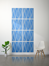 Eight blue tiles with white wavy engraved lines arranged in a 2x4 grid on a wall.