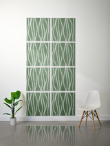 Eight green tiles with white wavy line engraving arranged in a 2x4 grid on a wall.