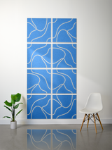 Eight blue tiles with tan engraved topographic contour lines arranged in a 2x4 grid on a wall.