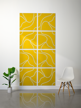 Eight yellow square tiles with white topographic line engravings arranged in a 2x4 grid on a wall.