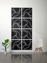 Eight black tiles with white engraved topographic line patterns arranged in a 2x4 grid on a wall.