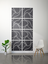 Eight dark gray tiles with white topographic line engravings arranged in a 2x4 grid on a wall.