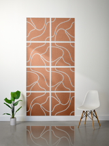 Eight terracotta tiles with white engraved curved topographic line patterns arranged in a 2x4 grid on a wall.