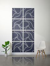 Eight dark blue tiles with white topographic line engravings arranged in a 2x4 grid on a wall.