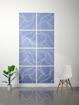 Eight blue tiles with cream-colored engraved topographic line patterns arranged in a 2x4 grid on a wall.