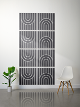 Eight charcoal tiles with white engraved geometric arch and line patterns arranged in a 2x4 grid on wall.