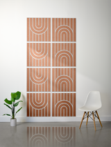Eight terracotta tiles with white engraved arch and line patterns arranged in a 2x4 grid on a wall.