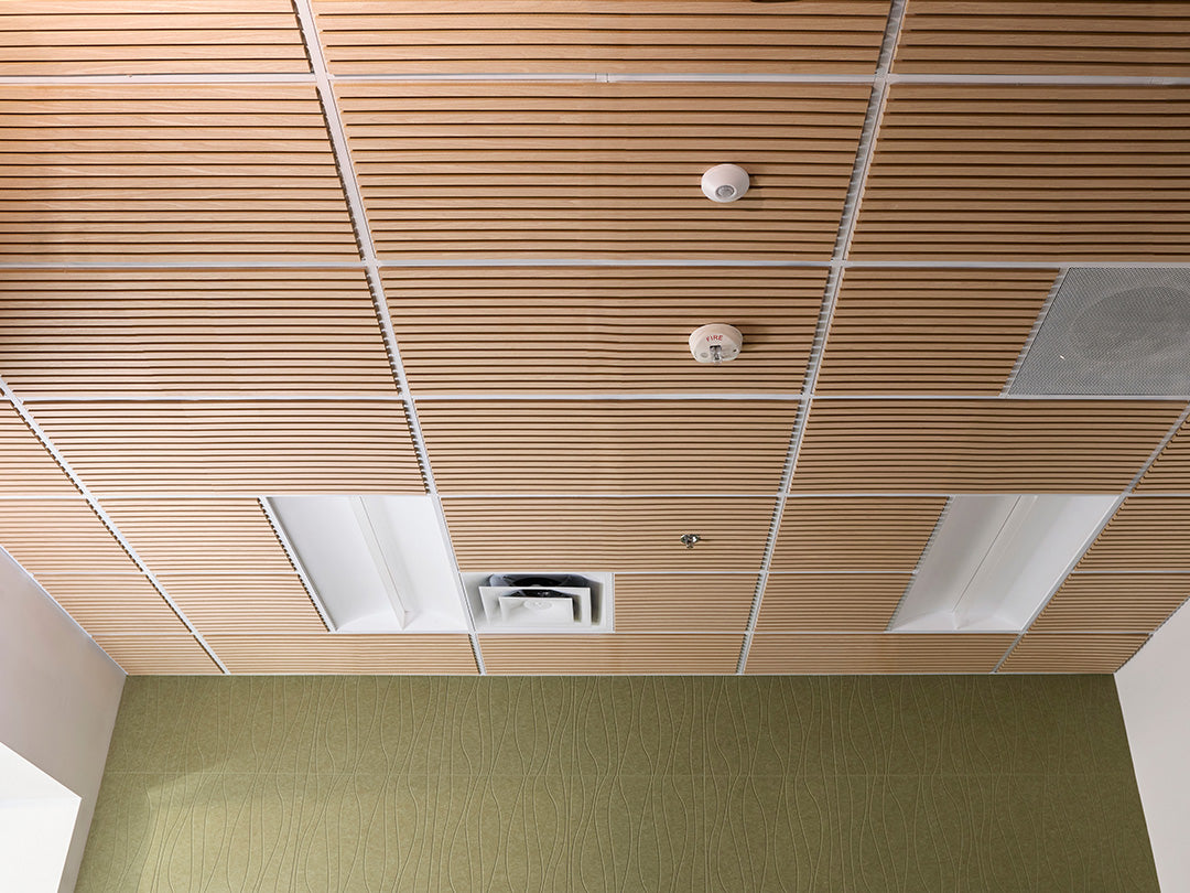 Ceiling with wooden paneling and air conditioning vent, green carpeted floor.
