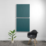 Two teal acoustic panels with engraved wavy river pattern mounted vertically on white wall.