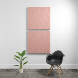 Two stacked pink acoustic panels with engraved wavy line patterns mounted on white wall.