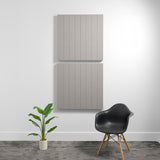 Two large beige acoustic wall panels with parallel vertical engraved lines mounted on white wall.