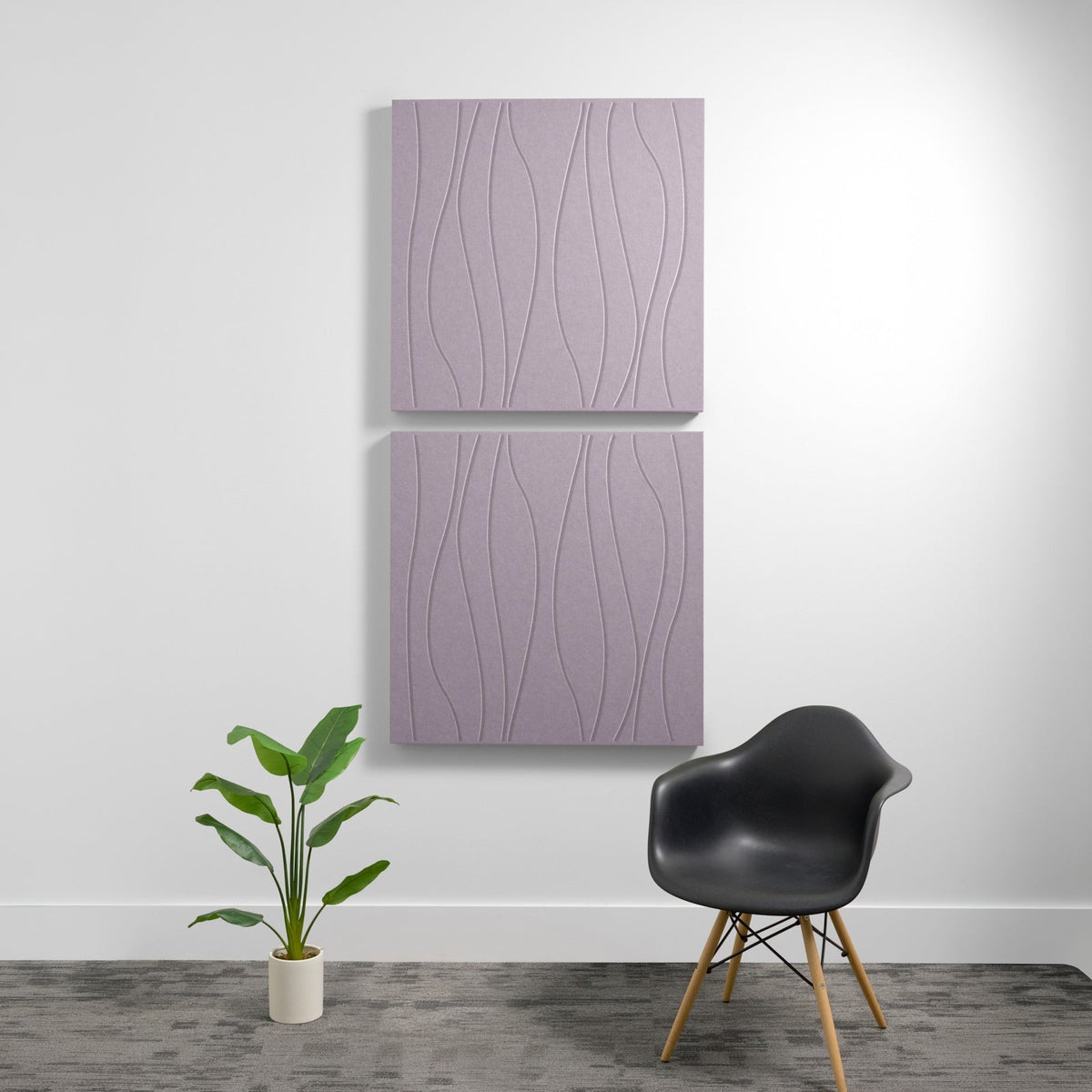 Two stacked mauve acoustic panels with wavy engraved texture mounted on wall above chair and plant.