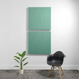 Two large green acoustic wall panels with wavy engraved pattern, mounted vertically on white wall.
