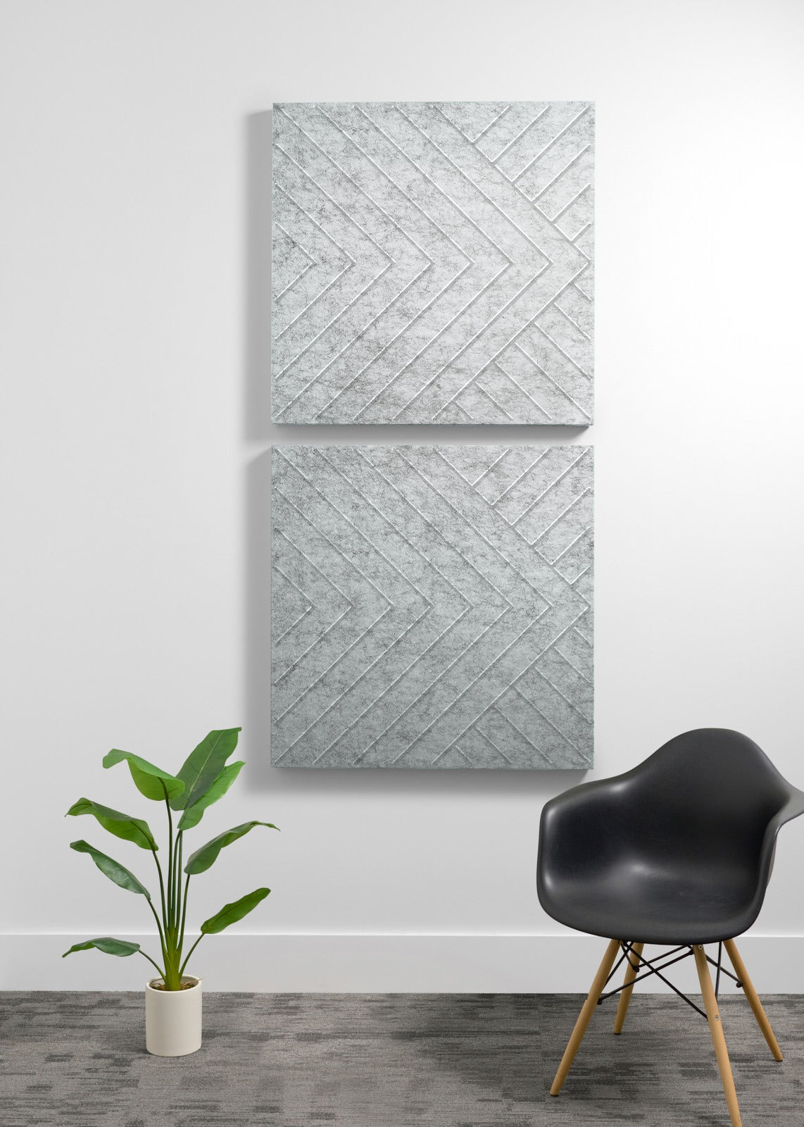 Two large square acoustic panels with herringbone texture pattern mounted vertically on wall.