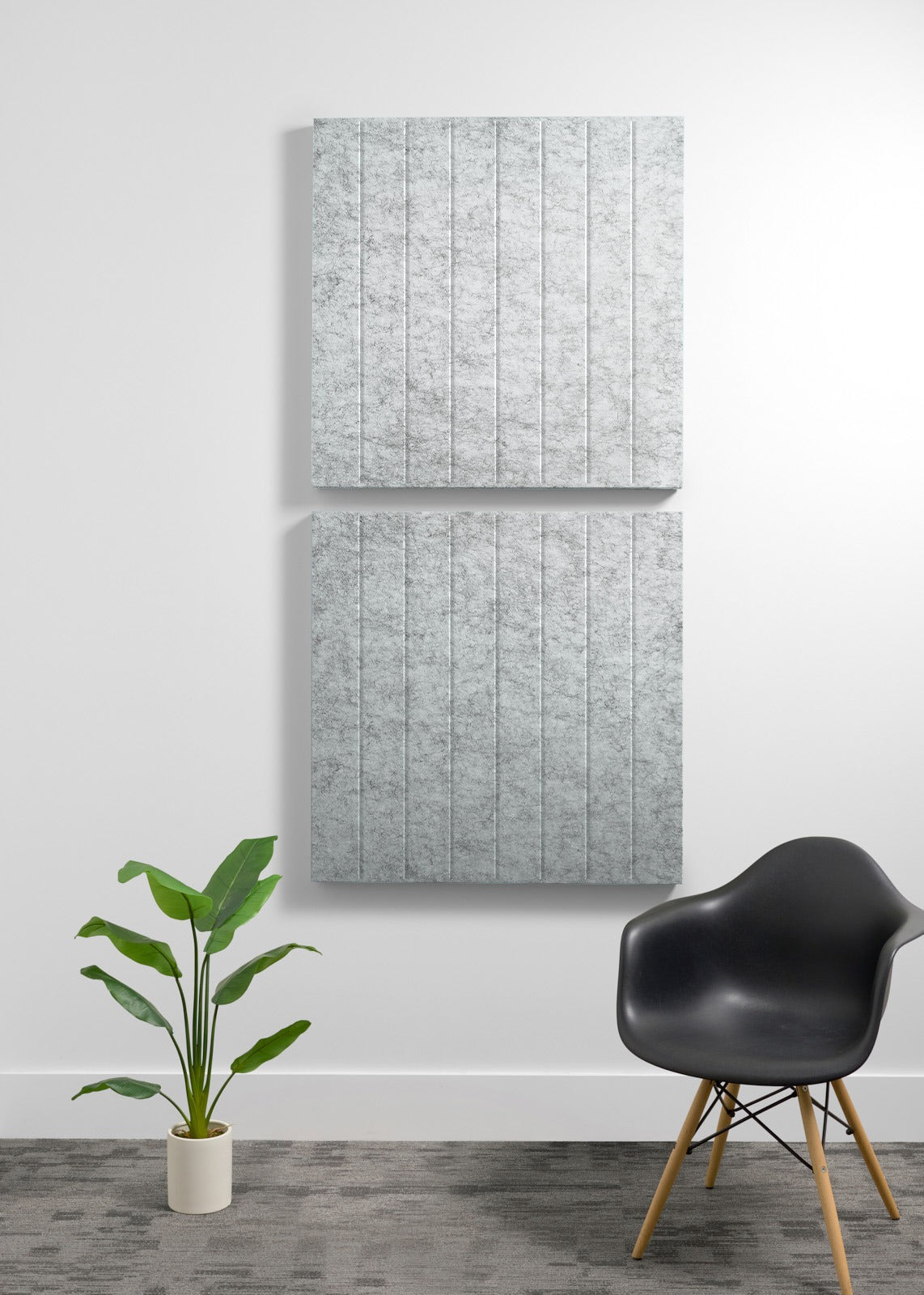 Two stacked gray acoustic wall panels with vertical ribbed texture mounted on white wall.