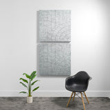 Two stacked gray acoustic panels with engraved vertical lines and curved arc patterns on a white wall.