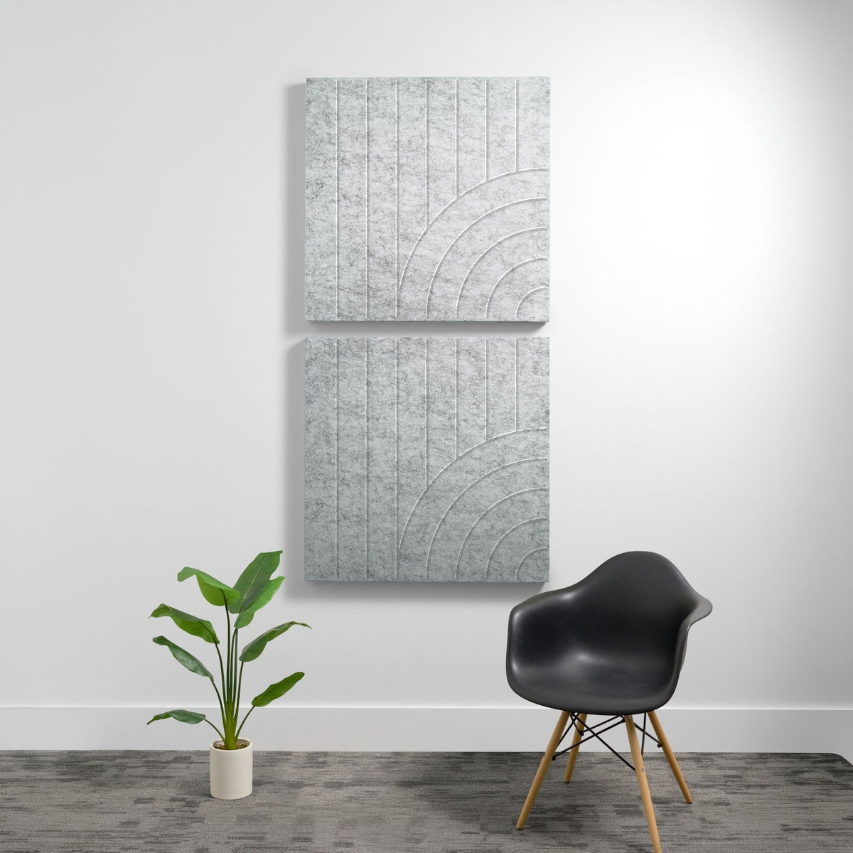 Two stacked gray acoustic panels with engraved vertical lines and curved arc patterns on a white wall.