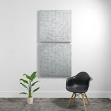 Two stacked square acoustic panels with engraved geometric arc patterns on textured gray surface.