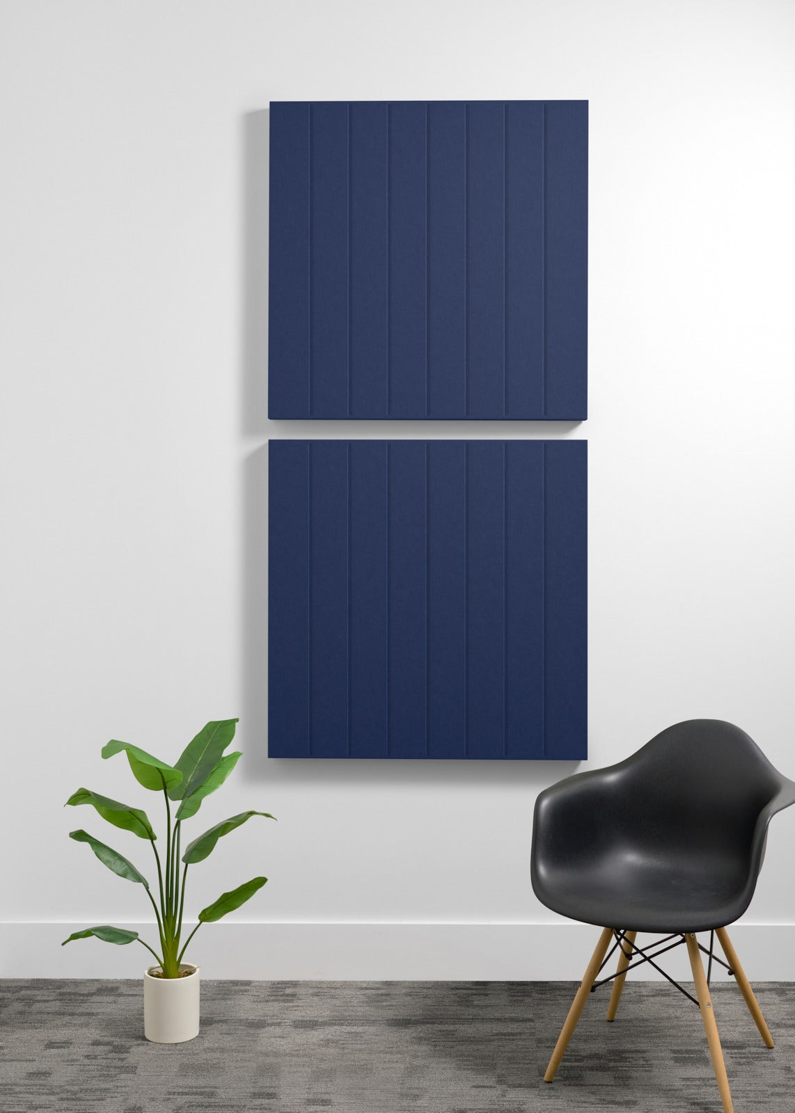 Two dark blue 3D acoustic wall panels with vertical ribbed texture mounted on white wall.