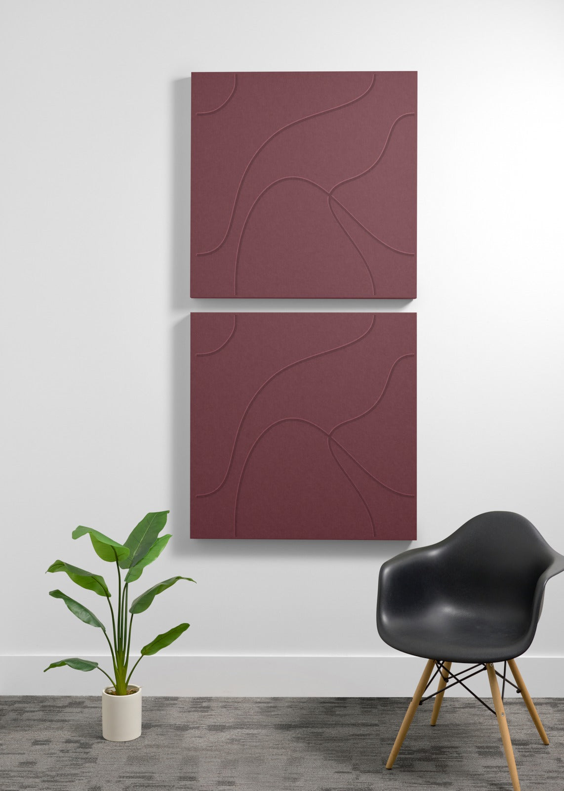Two stacked burgundy acoustic panels with engraved curved line patterns mounted on a white wall.