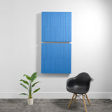 Two stacked blue acoustic panels with vertical engraved line patterns mounted on white wall.