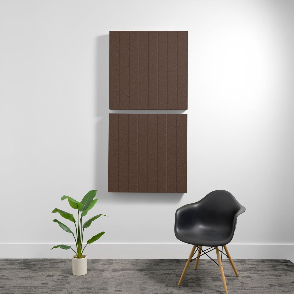 Two stacked brown wooden acoustic panels with parallel vertical engraved lines mounted on white wall.
