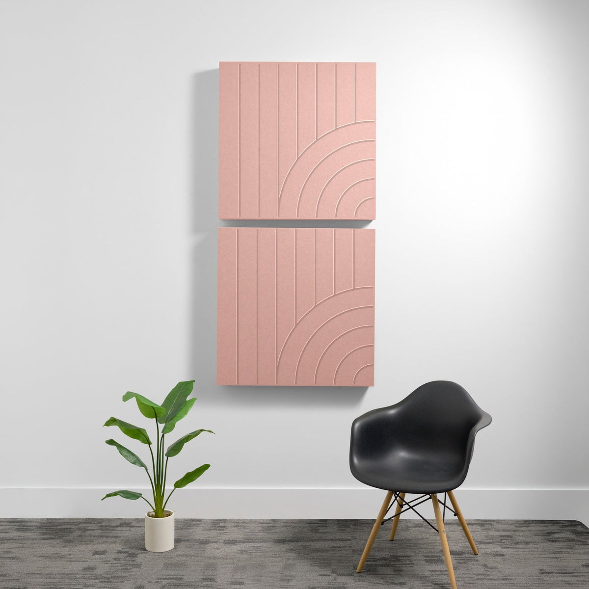 Two stacked pink acoustic panels with vertical line engraving and curved geometric patterns on a white wall.