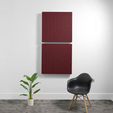 Two burgundy acoustic wall panels with engraved curved line patterns, mounted vertically on white wall.