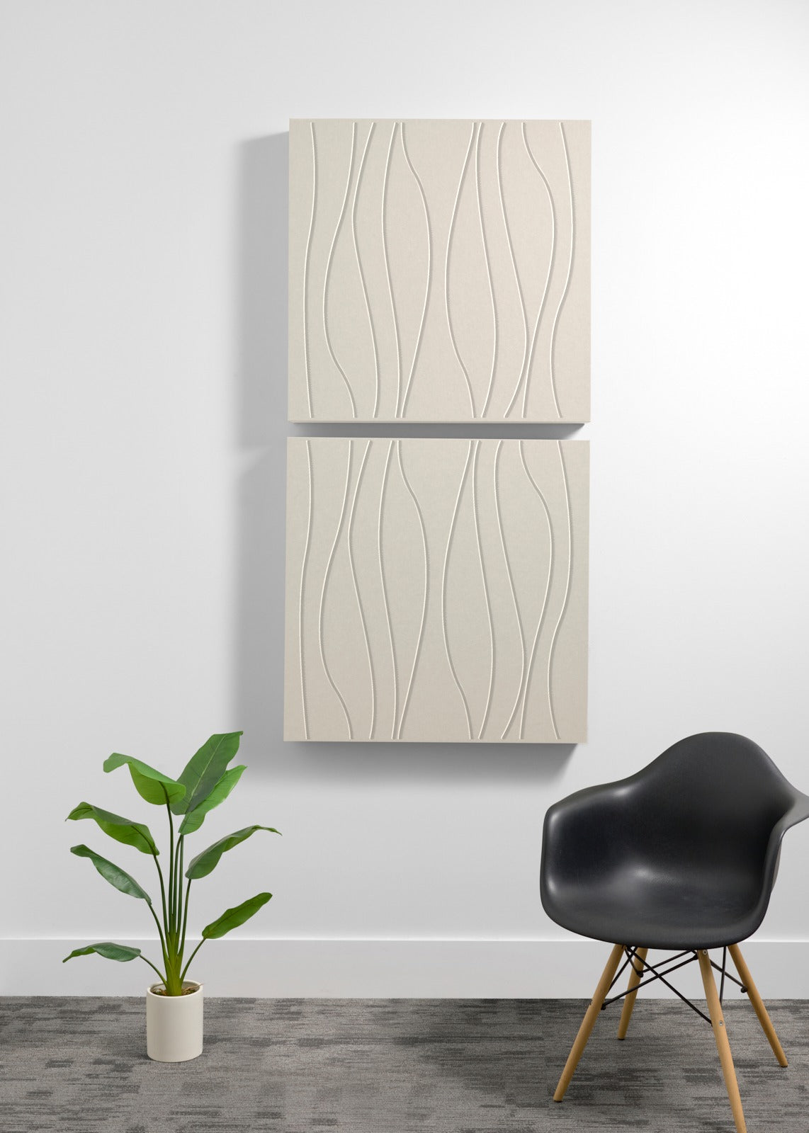 Two stacked cream-colored square panels with wavy engraved lines mounted vertically on a wall with metal trim between them.