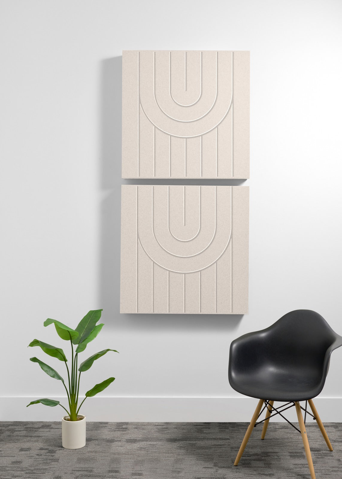 Two stacked cream-colored wooden acoustic panels with engraved arc patterns mounted on a white wall.