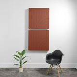Two stacked terracotta acoustic panels with engraved geometric arc patterns mounted on white wall.