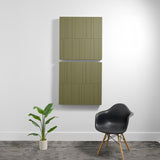Two stacked olive green acoustic panels with engraved linear patterns mounted on white wall.