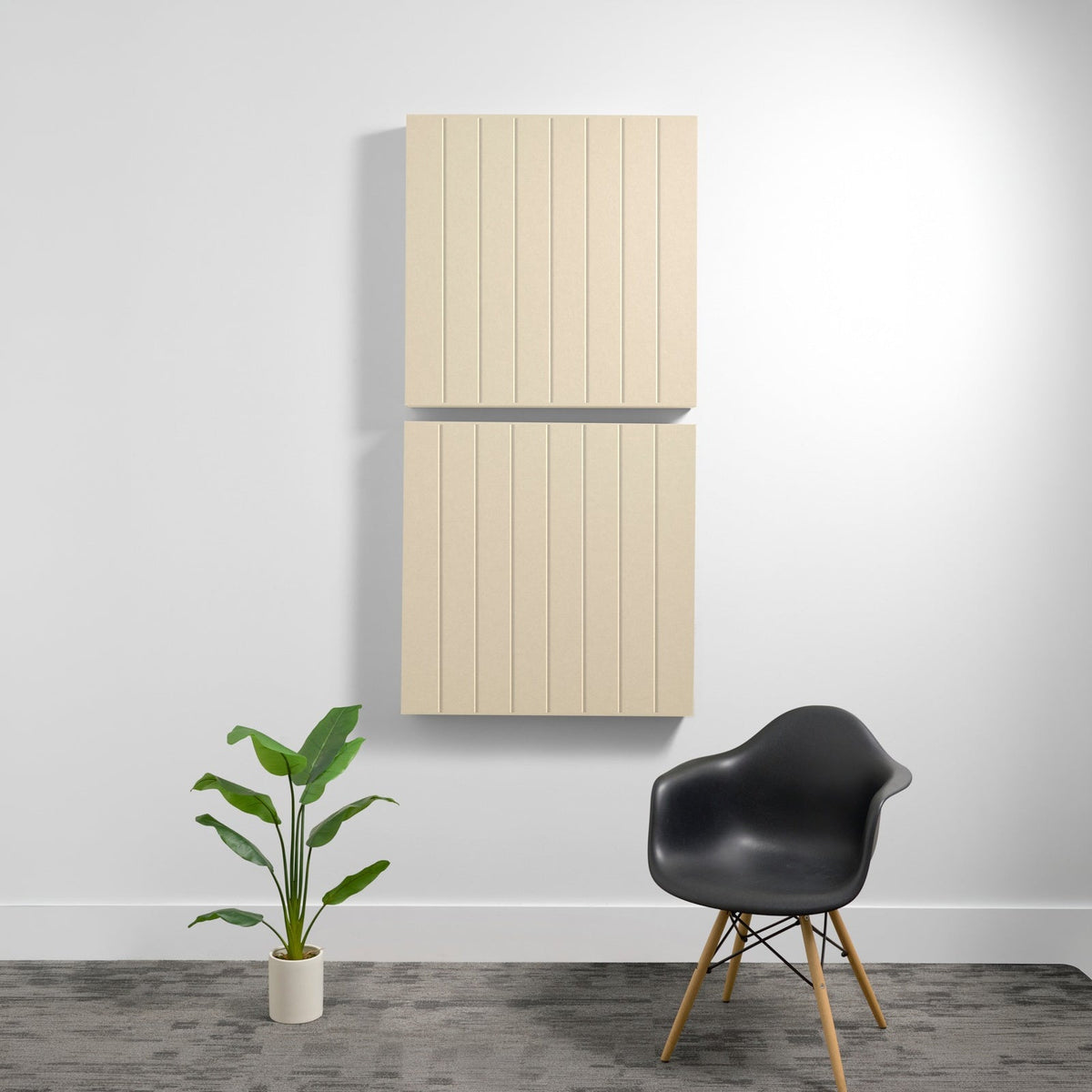 Two stacked light wood acoustic panels with parallel vertical engraved lines mounted on white wall.