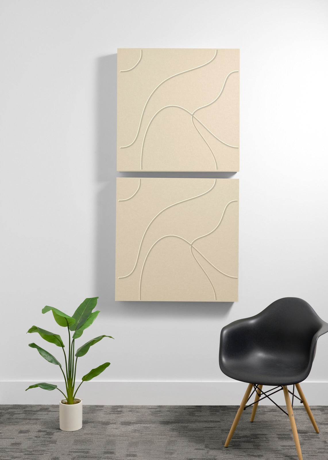 Two stacked beige square acoustic panels with engraved topographic line patterns on white wall.