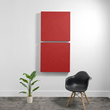 Two red acoustic boxes with topographic line engravings mounted vertically on a wall.