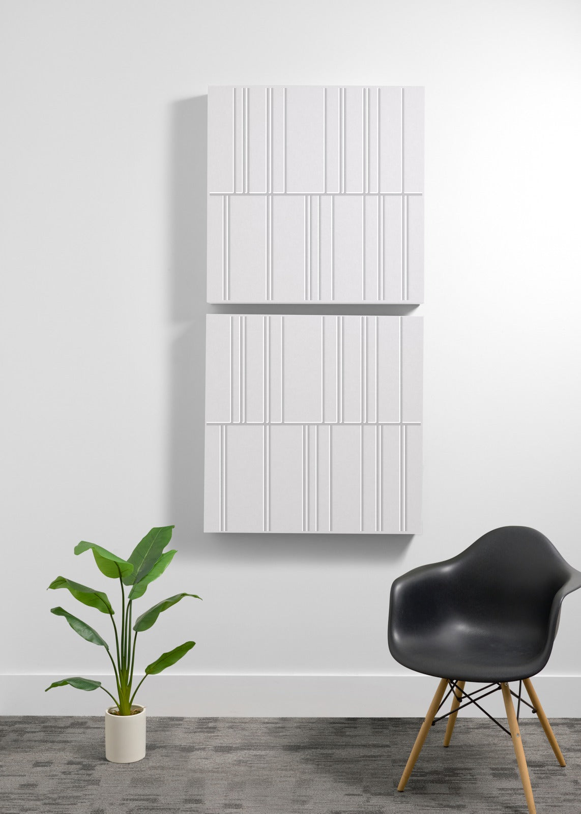 Four white acoustic wall panels with vertical engraved line patterns arranged vertically on a white wall.