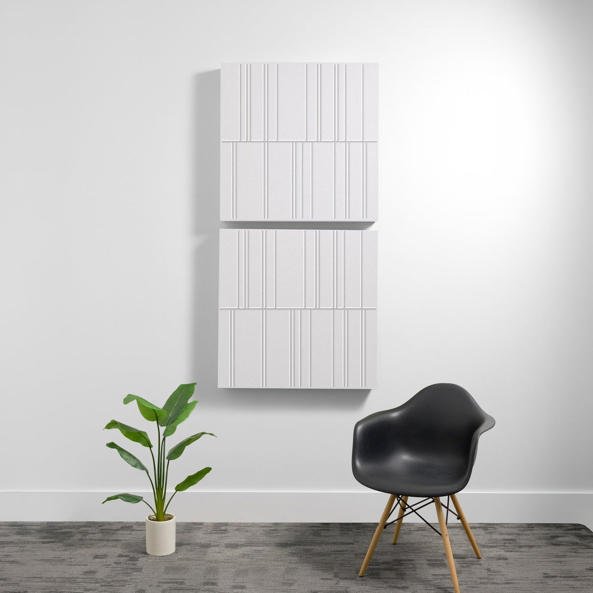 White acoustic wall panel with vertical engraved line pattern, mounted in stacked sections on gray wall.