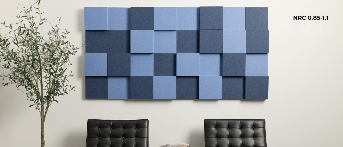 Acoustic wall panels in a geometric pattern on a white wall with two black chairs and a plant.