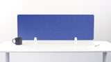 Blue rectangular desk divider with rounded corners mounted on white desk with black mug and notepad visible.
