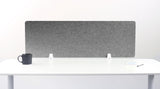 Gray felt desk divider with rounded corners mounted on white desk with support brackets.
