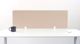 Beige desk divider panel with white mounting brackets on white desk surface.