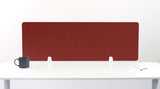 Burgundy desk divider panel with rounded corners mounted on white desk with support brackets, flanked by gray mug and notepad