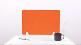 Orange wave desk divider with two curved cutout sections, positioned on white desk with office accessories.