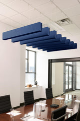 Multiple dark blue felt acoustic beams suspended from ceiling in office conference room setting.