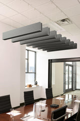 Gray felt acoustic beams suspended from ceiling in conference room setting.