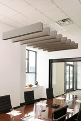 Multiple gray felt acoustic beams suspended from white ceiling in office conference room above wooden table.