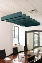 Multiple teal-colored acoustic ceiling beams suspended above a conference table in an office setting.