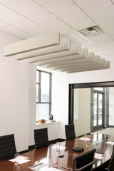 Cream-colored felt acoustic beams suspended from ceiling in conference room above wooden table.