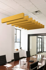 Multiple yellow felt acoustic beams suspended from ceiling above conference table in office space.