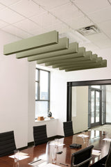 Sage green felt acoustic beams suspended from ceiling in staggered rows above conference table.